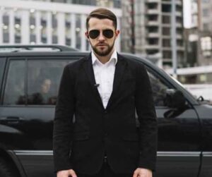 Bodyguard with a black dress,a bodyguard, a bodyguard giving security, a person giving security.