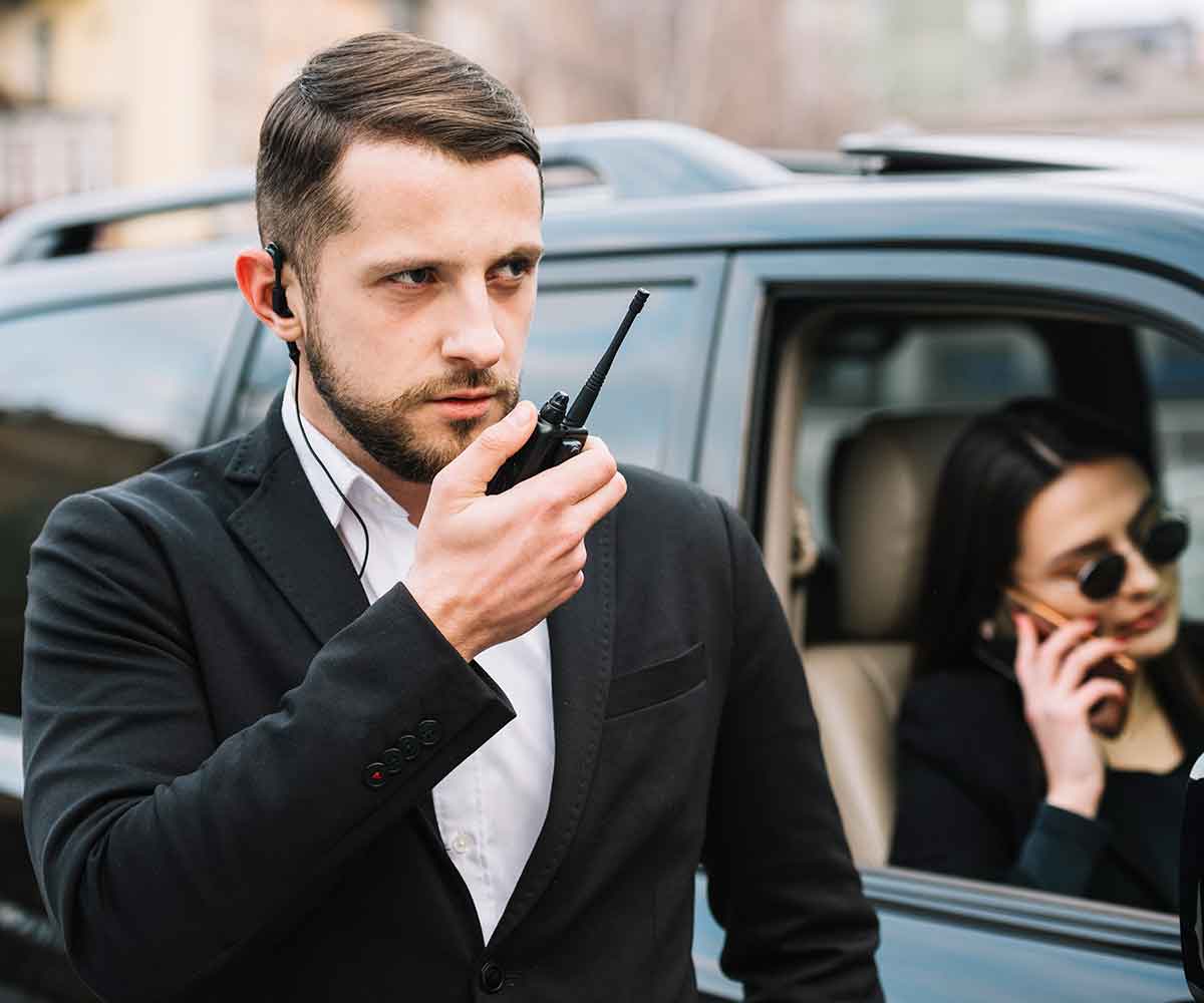 Bodyguard with a black dress,a bodyguard, a bodyguard giving security, a person giving security.