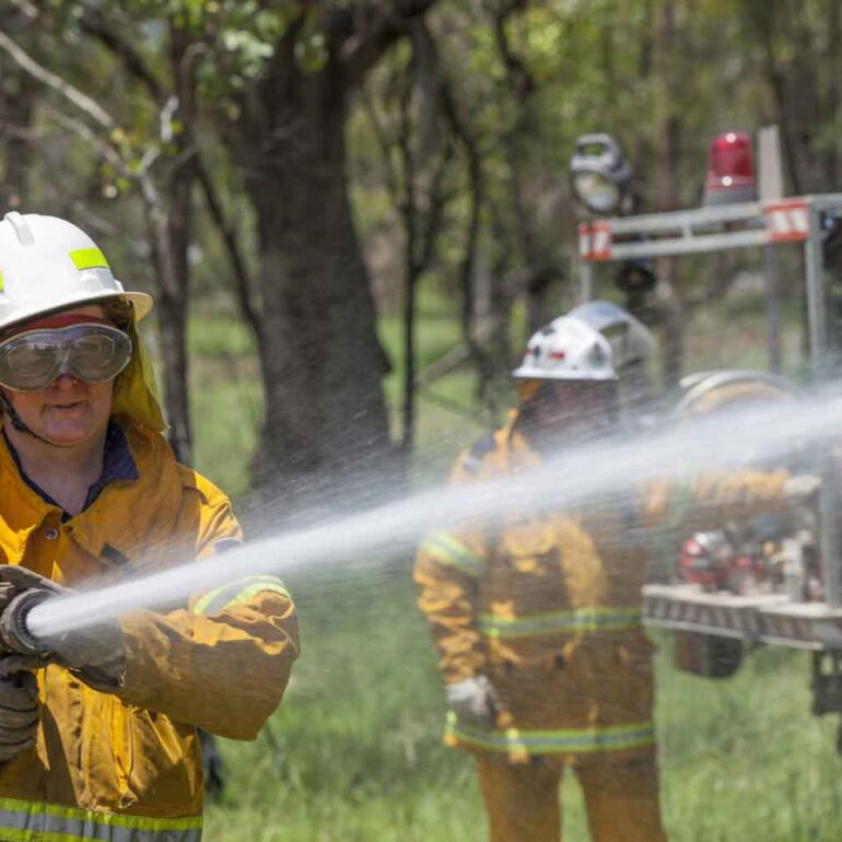 Firefighters, water blowing on the fire, cooling the fire with water, women cooling the fire,